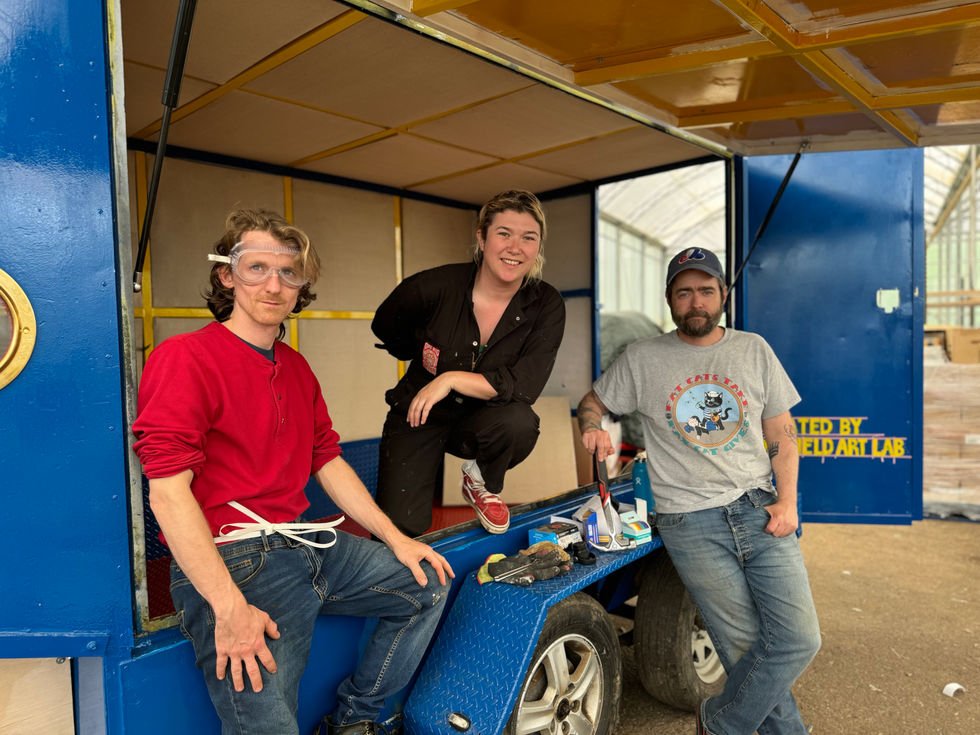 Idlefield Art Lab members Jake Nicoll, Ariel Sharratt, and Mathias Kom stand with the Phonoautobothy -- the mobile, solar-powered recording studio they built in Glasgow in the Spring of 2024.