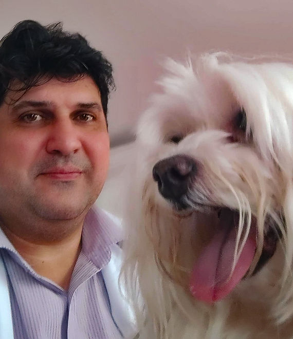 Veterinário da Zenpet ao lado de um cão de pelagem branca, demonstrando atendimento cuidadoso e especializado.