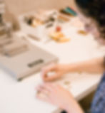 A woman arranging brass type to stamp pencils