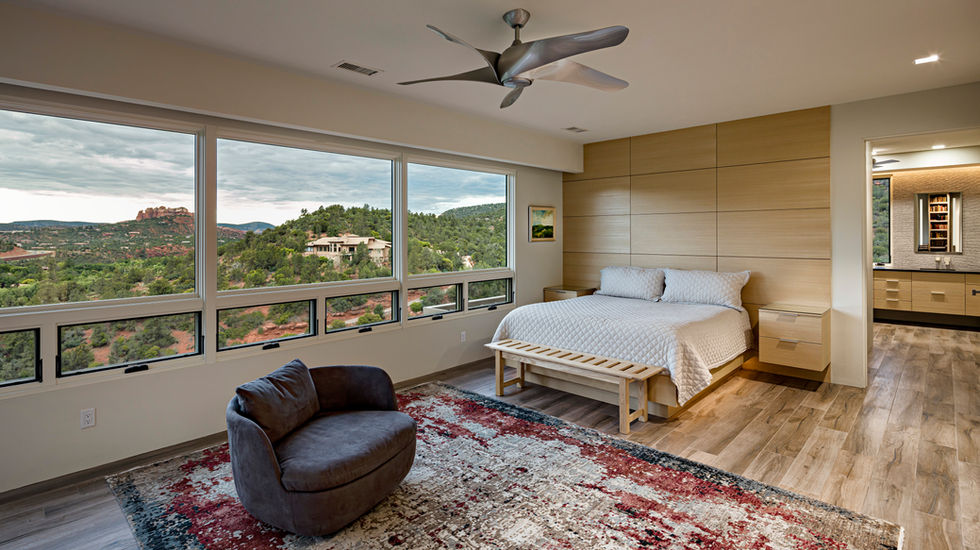 The master bedroom offers breathtaking views of Sedona's iconic red rock formations. The built-in bed and bed wall create a cozy and luxurious atmosphere, seamlessly blending with the natural beauty outside. The flooring is adorned with a beautiful rug that complements the earthy tones of the surroundings, adding warmth and comfort to the space. The combination of the iconic views, built-in bed, and beautiful flooring creates a serene and inviting retreat within the master bedroom.