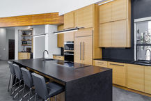 The guest side of a kitchen island with a waterfall edge typically serves as a social and functional space in the kitchen. Some important features of this area include:
1. Overhang: The guest side of the island usually has an overhang to accommodate seating, allowing guests to sit comfortably while interacting with the cook or enjoying a meal.
2. Countertop Material: The choice of countertop material is crucial, as it should be durable and visually appealing. Common options include quartz, granite, marble, or wood.
3. Waterfall Edge: The waterfall edge itself is a prominent feature, where the countertop material cascades down the sides of the island, creating a sleek and modern look.
4. Integrated Appliances: Some kitchen islands may feature integrated appliances on the guest side, such as a wine fridge, microwave, or additional storage, to enhance functionality and convenience for both the cook and guests.
5. Lighting: Adequate lighting above the guest side of the island is essential for creating a welcoming ambiance and ensuring visibility for tasks such as eating, conversing, or socializing.
6. Seating: Whether it's bar stools or chairs, comfortable and stylish seating is important for the guest side of the island, encouraging guests to linger and enjoy the space.
Overall, the guest side of a kitchen island with a waterfall edge should be designed with both aesthetics and functionality in mind, creating a welcoming and practical area for socializing and dining.
