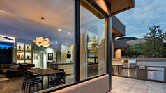 The patio is adorned with a stunning outdoor kitchen, creating a beautiful and functional space for cooking and entertaining. The open-air design allows for a seamless transition between indoor and outdoor living, making it the perfect setting for enjoying meals with family and friends. The combination of natural materials and modern appliances adds a touch of elegance to the outdoor space, creating a luxurious and inviting atmosphere. Whether it's grilling up a feast or simply enjoying a morning coffee in the fresh air, this outdoor kitchen is sure to be a favorite spot for gathering and relaxation.