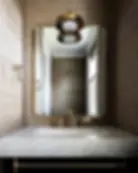 “Elegant powder room at 27 Howard featuring a decorative mirror and modern fixtures.”