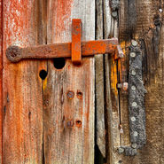 Rusty latch on weathered wooden door
