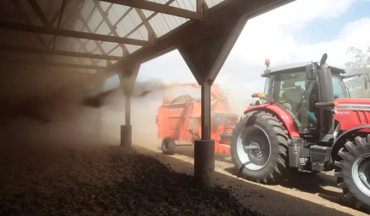 KUHN PRIMOR Bale Processor attached to tractor rear, blowing straw