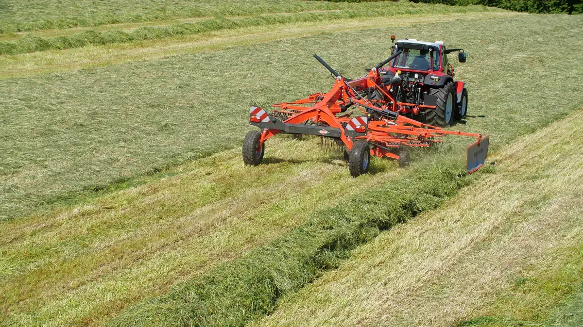 GA 1032+ Series Twin-Rotor Rotary Rake attached to tractor rear, in field