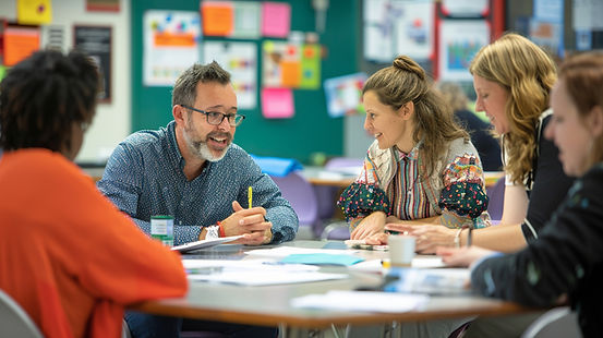 educators talking around a table during professional leadership session