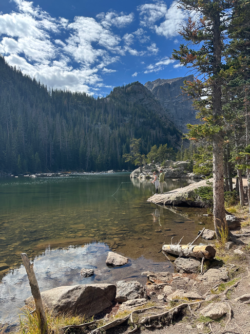 someone fishing on dream lake in rocky mountain national park