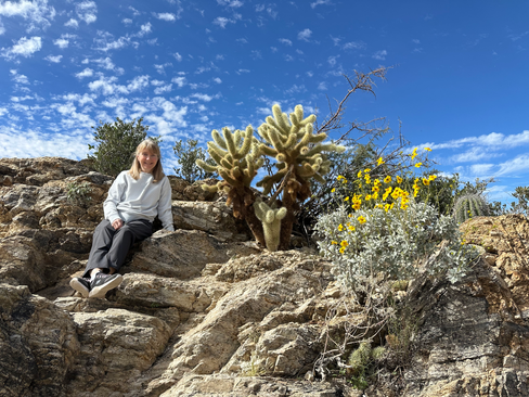 my mom sitting with cactuses on javelina rocks in saguaro national park arizona