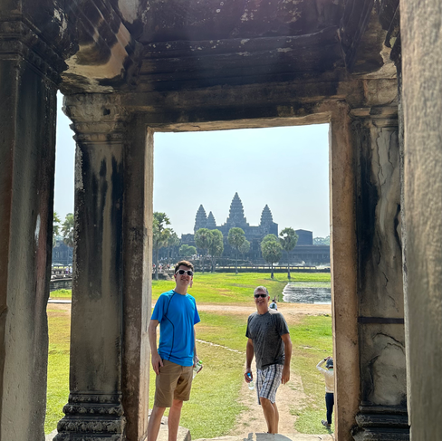 people climbing stairs to angkor wat cambodian temple