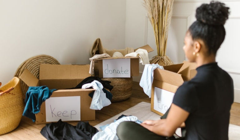 A woman sitting in front of cardboard boxes