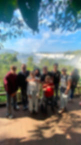 Group photo of travelers in front of Iguazu Falls with a WS TOURS guide