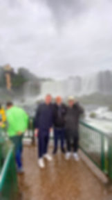 Family posing in front of Iguazu Falls on a private tour, Brazilian side