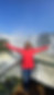 Woman standing alone in front of Iguazu Falls with arms open on a private tour