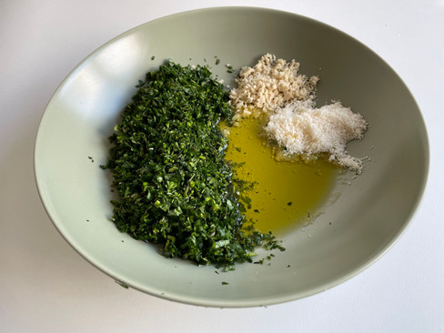 Zutaten für ein leckeres Wildkräuterpesto in einem grünen Teller