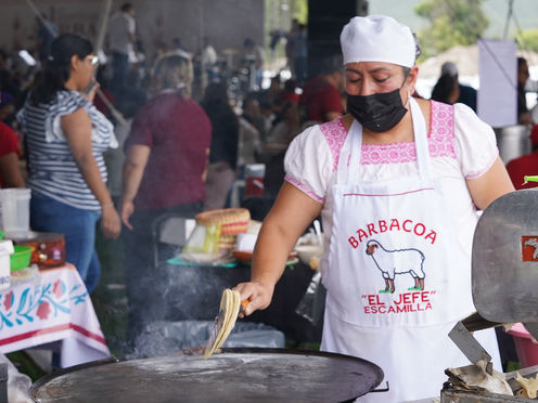 Expositores sirviendo consomé y platillos tradicionales durante el Festival de la Barbacoa del Valle del Mezquital en Hidalgo.
