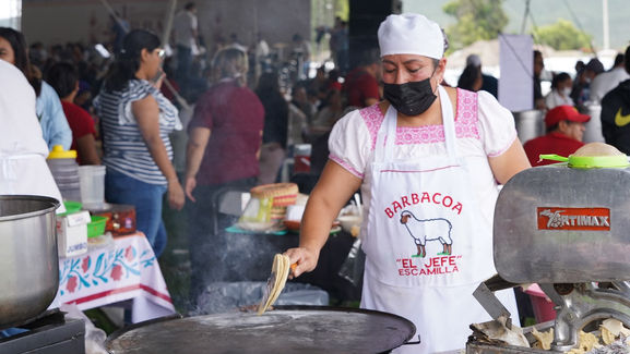 Expositores sirviendo consomé y platillos tradicionales durante el Festival de la Barbacoa del Valle del Mezquital en Hidalgo.