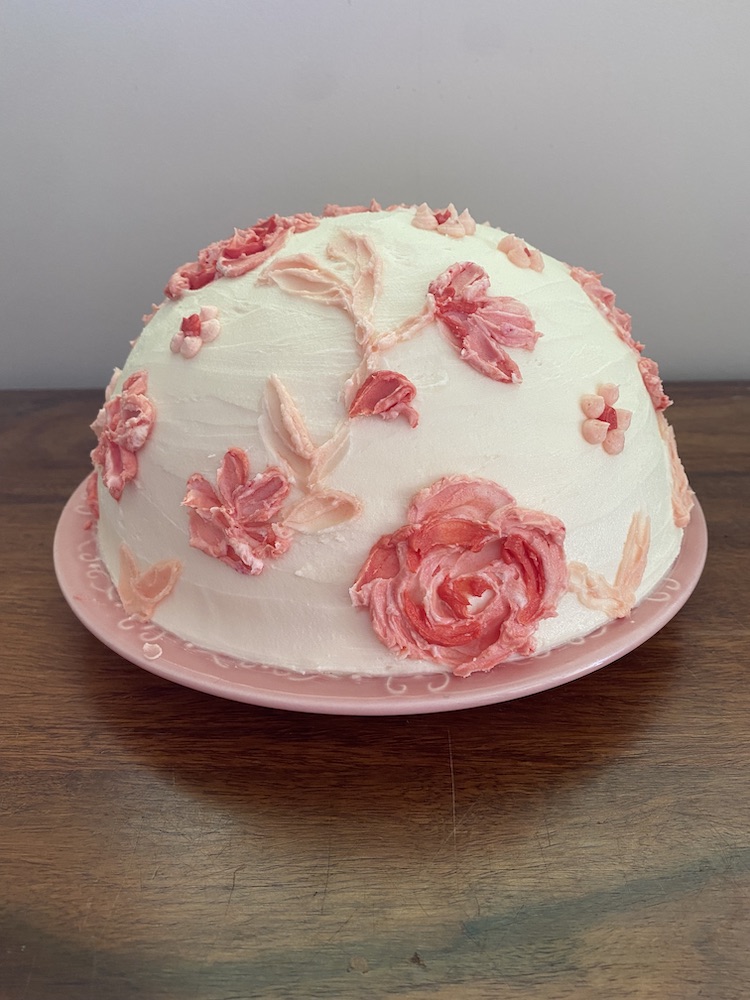 A cake covered in pink buttercream flowers