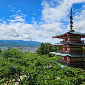 Blick auf die rote Chureito Pagode und den Mount Fuji der von Wolken umgeben ist