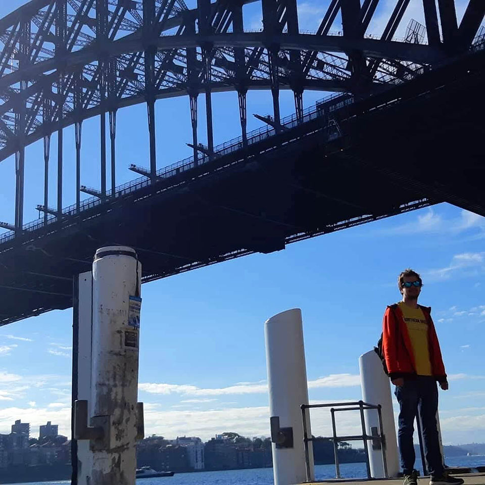 Mann aus der Froschperspektive vor dem Hintergrund der Sydney Harbour Bridge