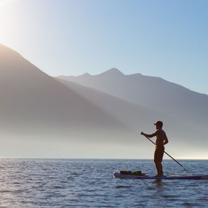 A man paddleboarding on Kootenay Lake at Sunset