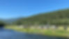 Many camping trailers and RVs parked along the edge of the Moyie River in the Creston Valley.