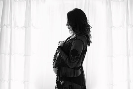 Pregnant woman in a white dress posing in a professional studio maternity photoshoot in Berkshire.