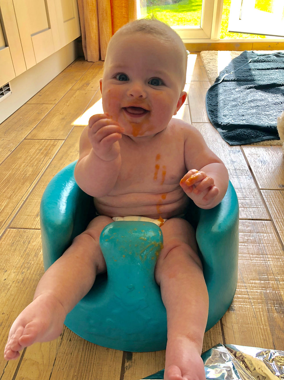 Premature baby in bumbo seat introducing solid foods and weaning