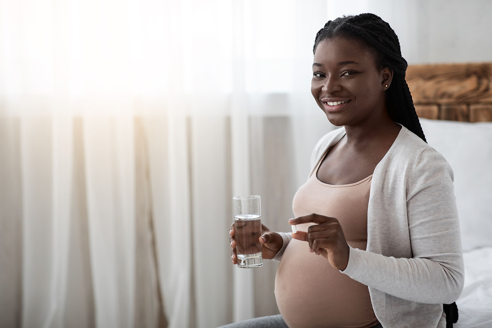 Black pregnant women holding pregnancy supplements