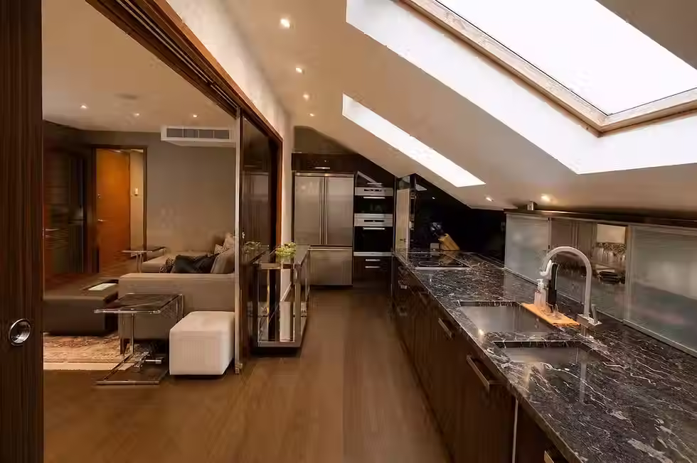 Contemporary kitchen with skylights and dark marble worktops