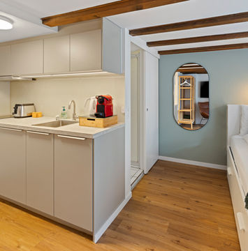 Combined view of kitchen, living area, and bedroom in Ariser - Zug Unique Apartment in Historic Building.

