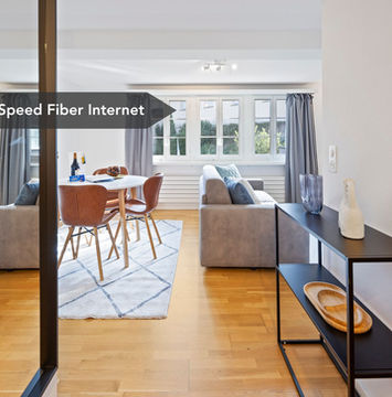 Bright living room with dining table and wooden floor in Zug apartment