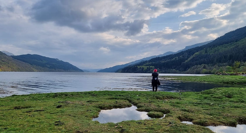 Carolyn standing at the edge of Loch Awe taking a photograph