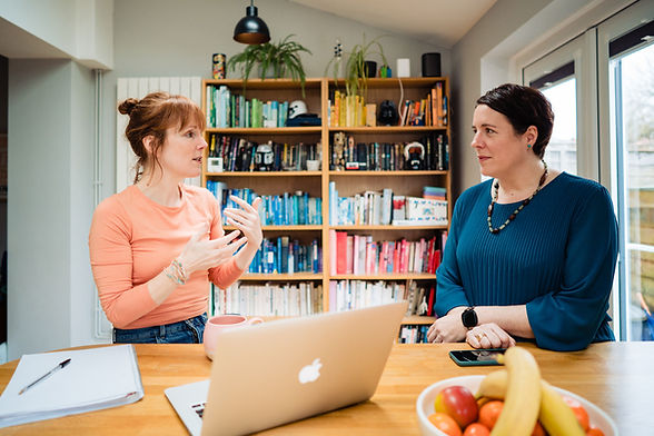 Fiona and her coachee are talking in front of a bookcase