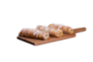 Four glazed pastries on a wooden board. Delicious looking dessert treats.