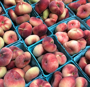 Fresh, ripe peaches arranged in blue baskets at the farmer's market.