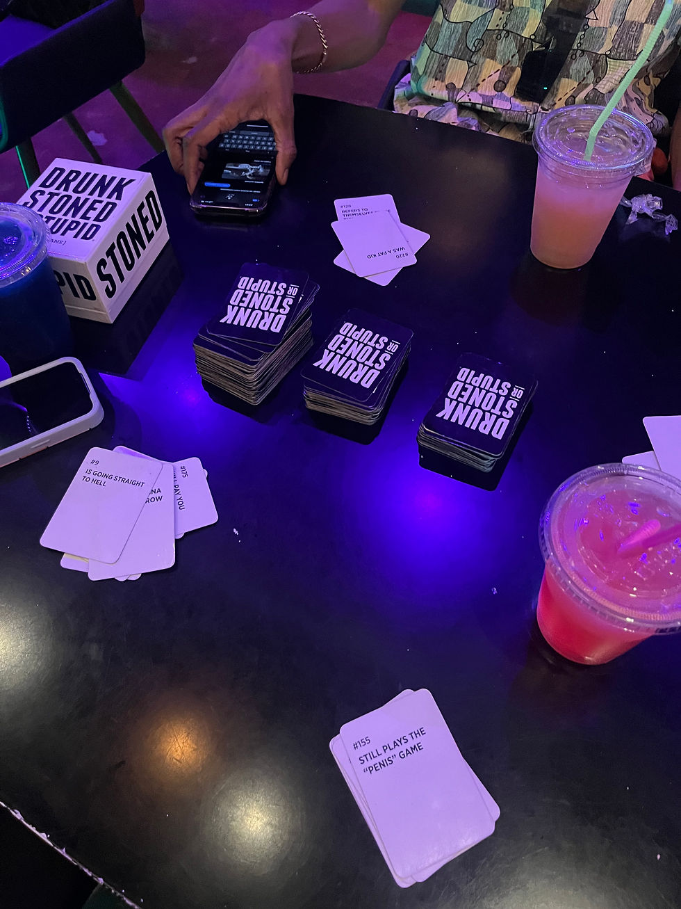 The game "Drunk, Stoned, or Stupid" actively being played by three people in a party setting