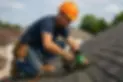 worker-in-a-hard-helmet-installing-shingles-on-a-rooftop.webp