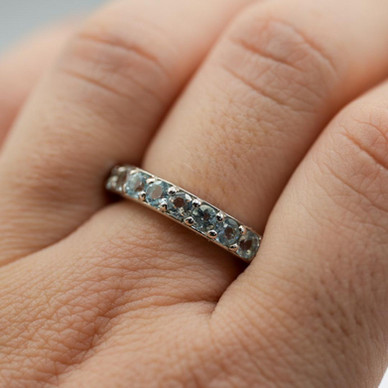 Bague rhodié - Alliance en sertis de topaze bleue.