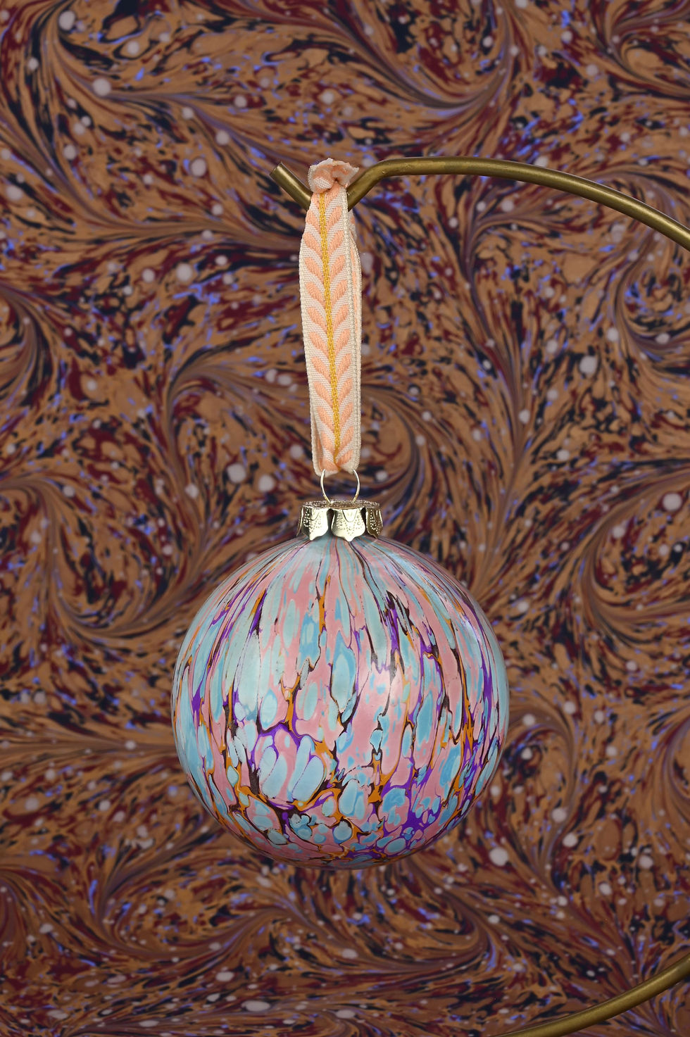 Thumbnail: Close up on a marbled bauble with embroidered ribbon.