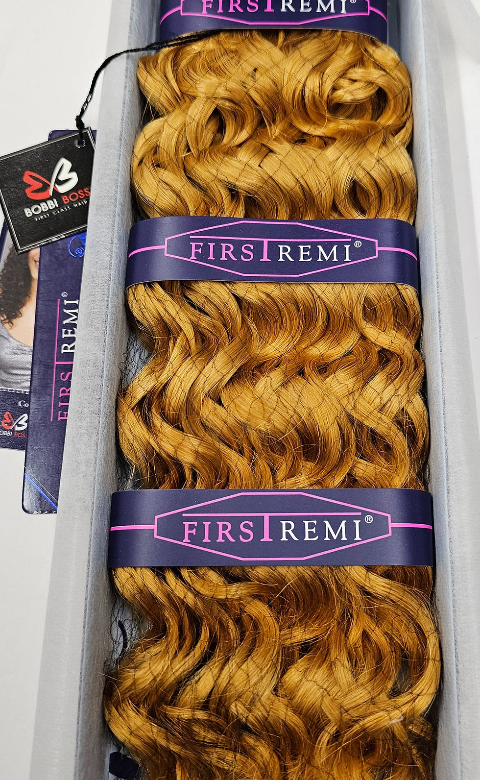 Thumbnail: Bundles of wavy golden hair extensions with FIRST REMI bands