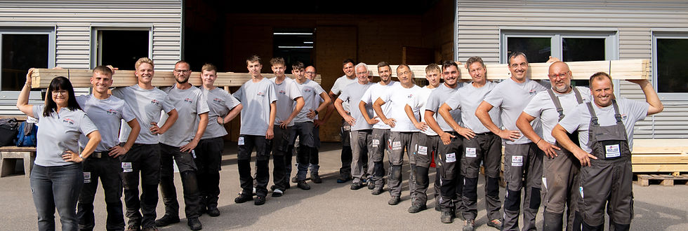 Team Braun und Heine rechts und links aufgestellt, stehen in einer Reihe und halten einen Balken