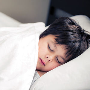 Boy sleeping in bed.