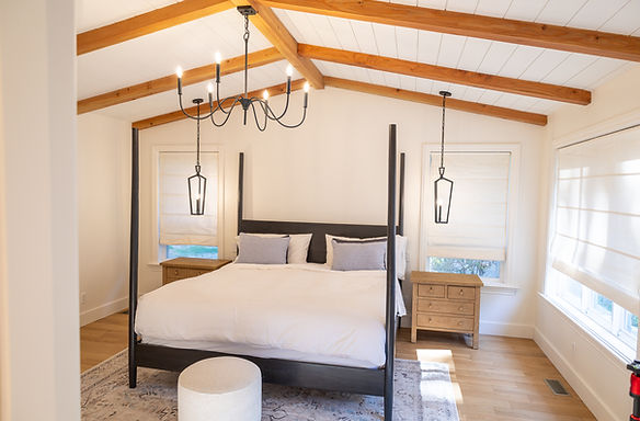 Primary bedroom with Currey & co Tirrell small chandelier and Kichler Abbotswell pendants