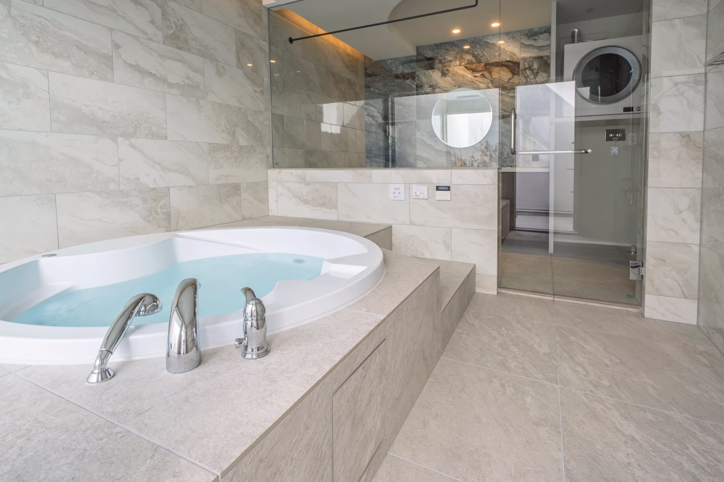 在来工法施工事例④|ガラス越しに中庭が見えるジェットバスとブルータイルのホテルライクな浴室