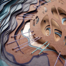 paper sculpture with stitching in purples, aqua, and burnt orange