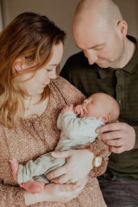 Gezin tijdens newbornfotoshoot op slaapkamer omgeving Eindhoven newbornfotograaf