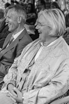 ouders van bruid lachen tijdens ceremonie