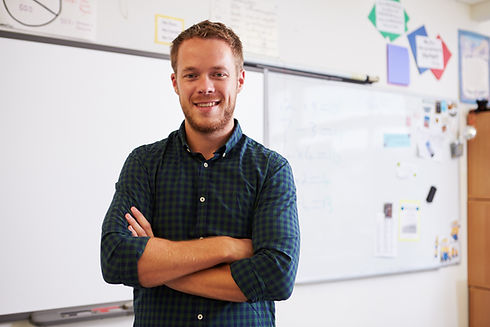 Portrait of confident Caucasian male teacher in classroom.jpg