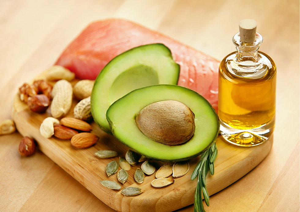 Avocado, nuts, seeds, salmon, and a vial of oil on a wooden board. Warm tones, healthy food setting.